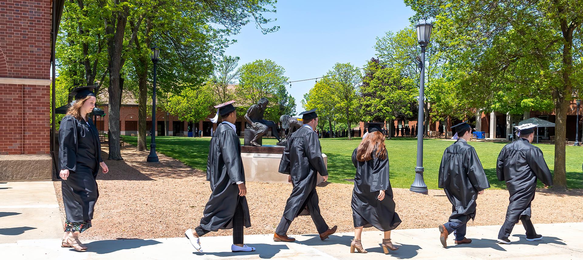 Students walking in front of Divine Servant statue